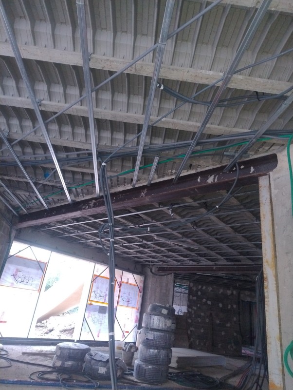 Pose d'un faux plafond suspendu sur une ossature métallique par un artisan plaquiste à la Garde